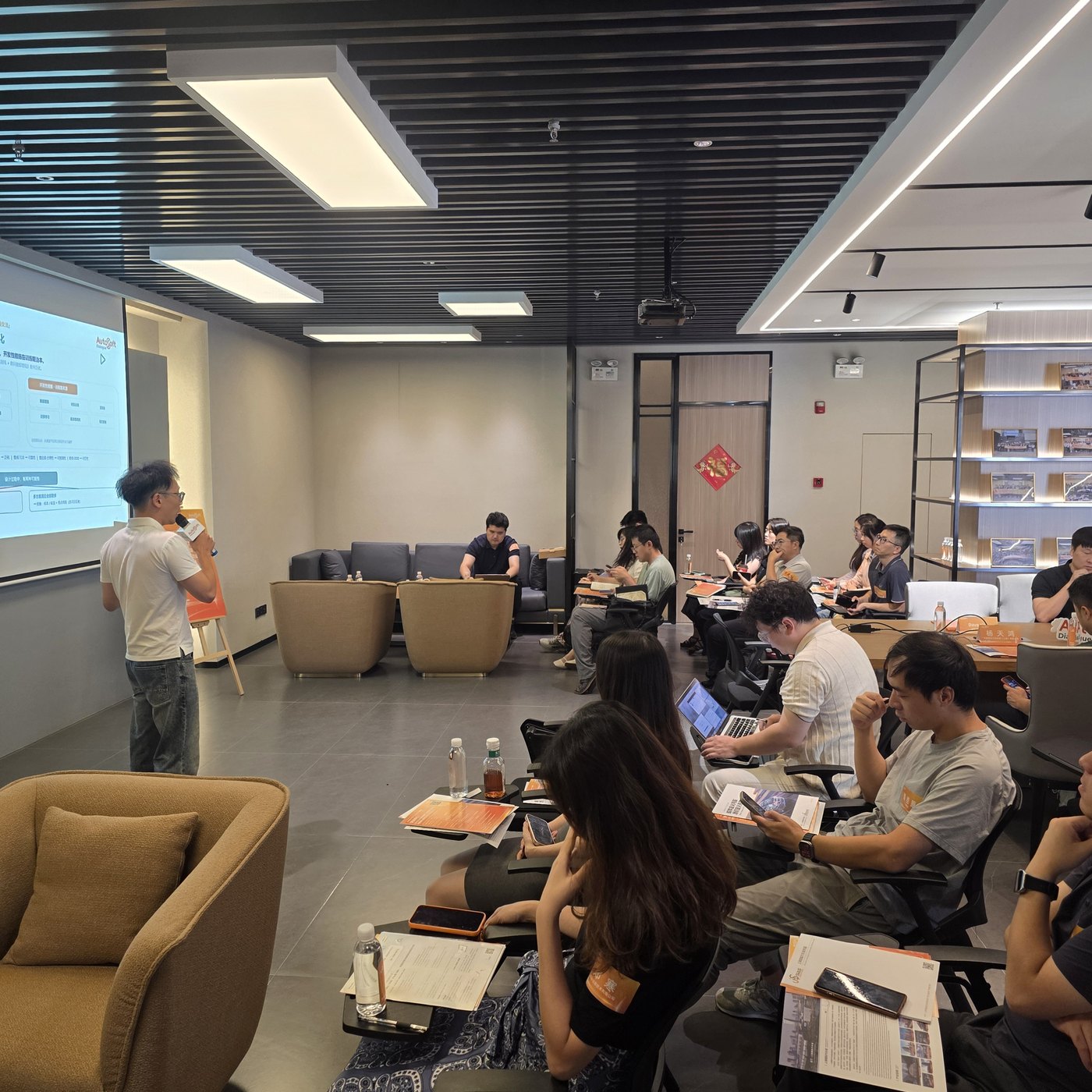 活动现场 —— 参会者坐在沙发和座椅上观看演示屏幕（上海国际汽车城 AutoSoft 会场）